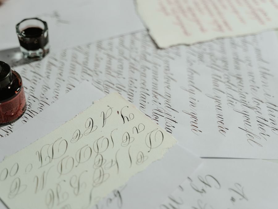 Calligraphy sheets, ink and pen on a white surface